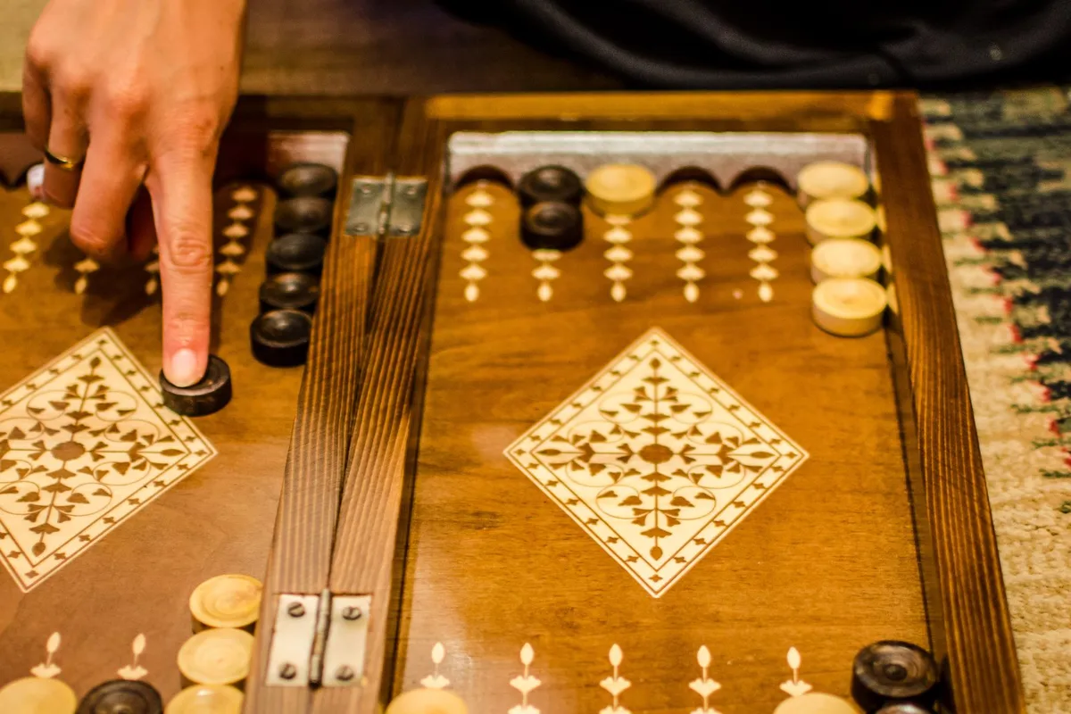 Bringing a checker home on an inlaid board in Iran, where the game has been played as nard for some fifteen hundred years.