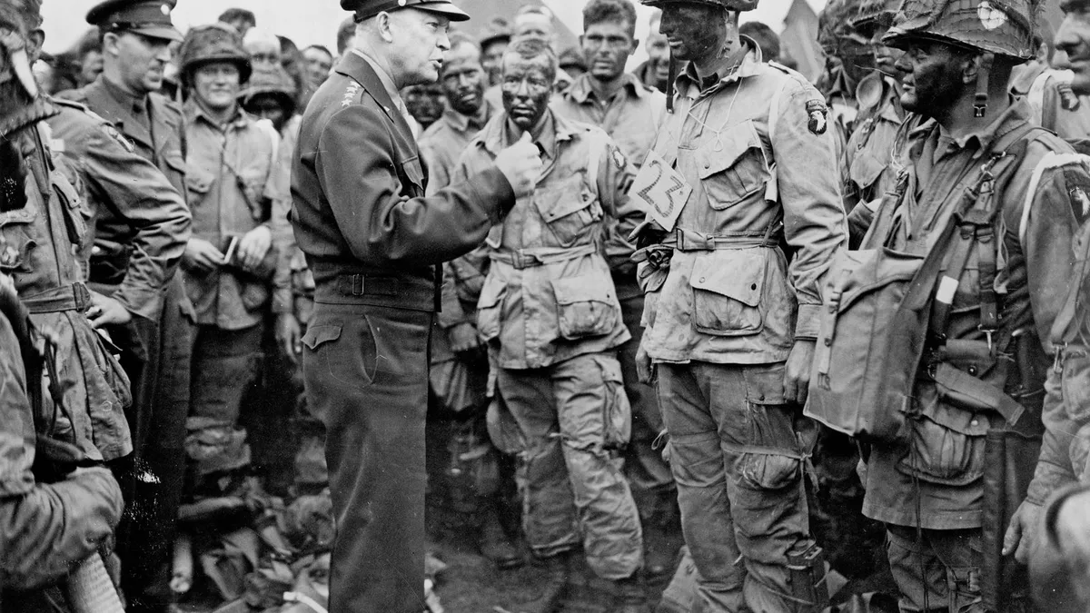 General Dwight D. Eisenhower talking with American paratroopers in England on 5 June 1944, the men in jump trousers with large thigh pockets