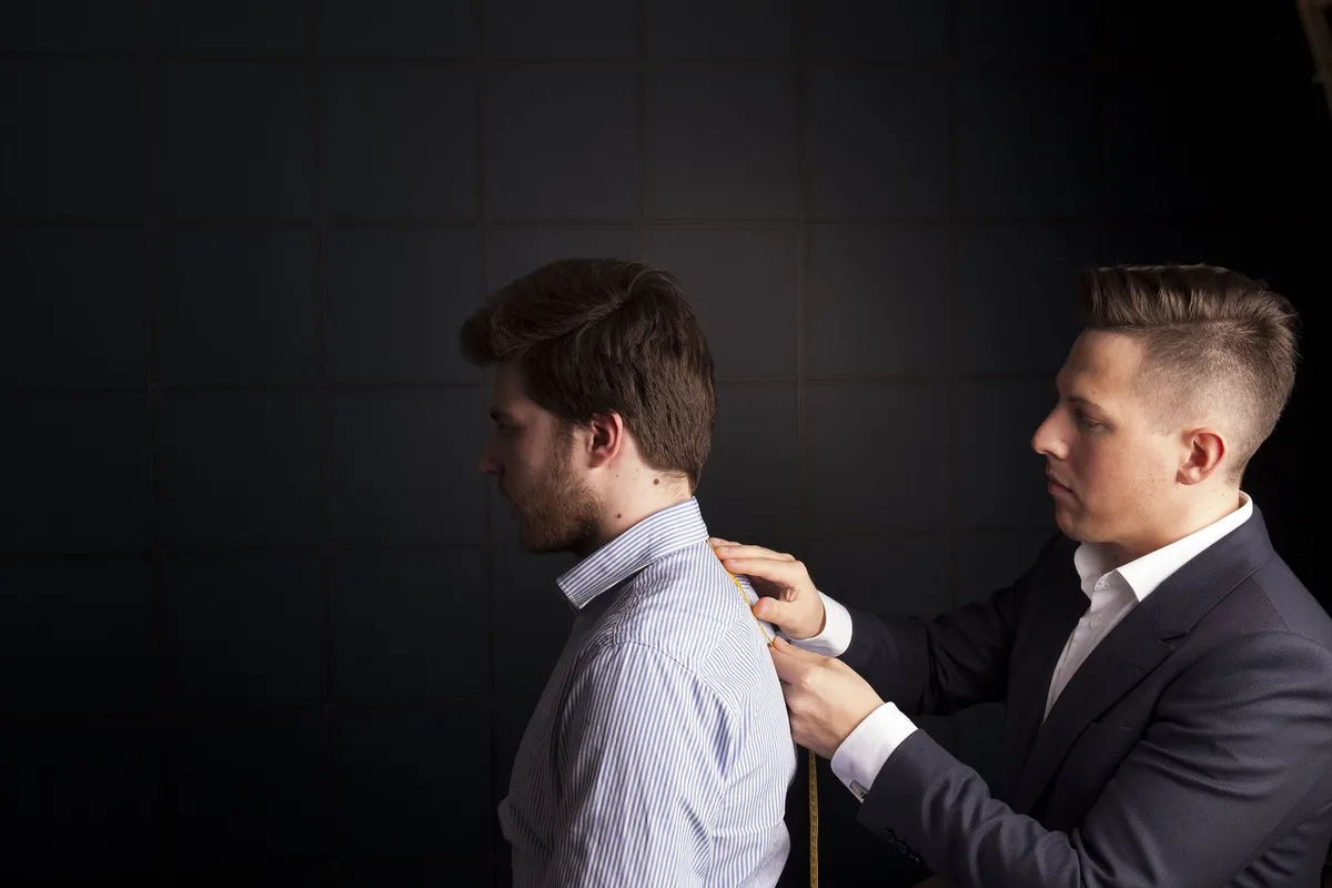 Fit comes before fabric, brand or label. A tailor takes a client's measurements.